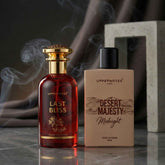 Two perfume bottles, 'Last Bliss' and 'Desert Majesty Midnight', with smoke in the background.